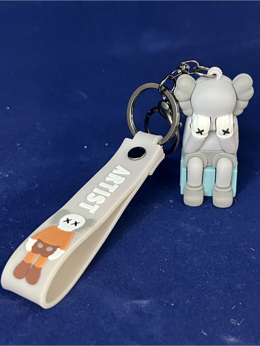 Gray and Light Blue Kaws Figure Keychain with White Strap